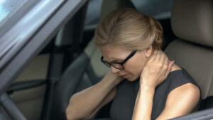 Exhausted woman feeling neck pain, sitting in automobile, spinal problem, health