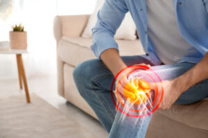 Man suffering from chronic knee pain at home