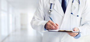 primary care physician writes notes on the clipboard