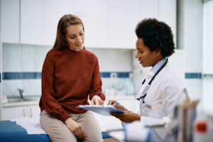 Happy woman going through her medical data with primary care physician