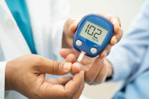 Doctor check diabetes from finger blood sugar level with finger lancet.